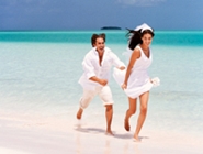 honeymoon couple running along the beach